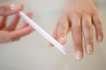 Close up of Hispanic woman filing her nails 