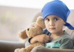 Little boy and his teddy bear after a chemotherapy treatment 