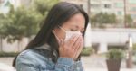 Woman coughing with wearing face mask at outdoor 