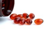 Few lecithins capsules near an open bottle 