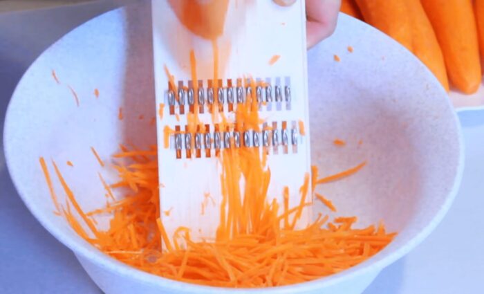 Натріть моркву за допомогою спеціального кухонного девайса