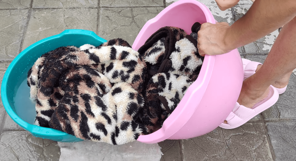 Мудра подруга навчила, як випрати величезний плед, який не влазить в пралку: метод “равлика” працює 